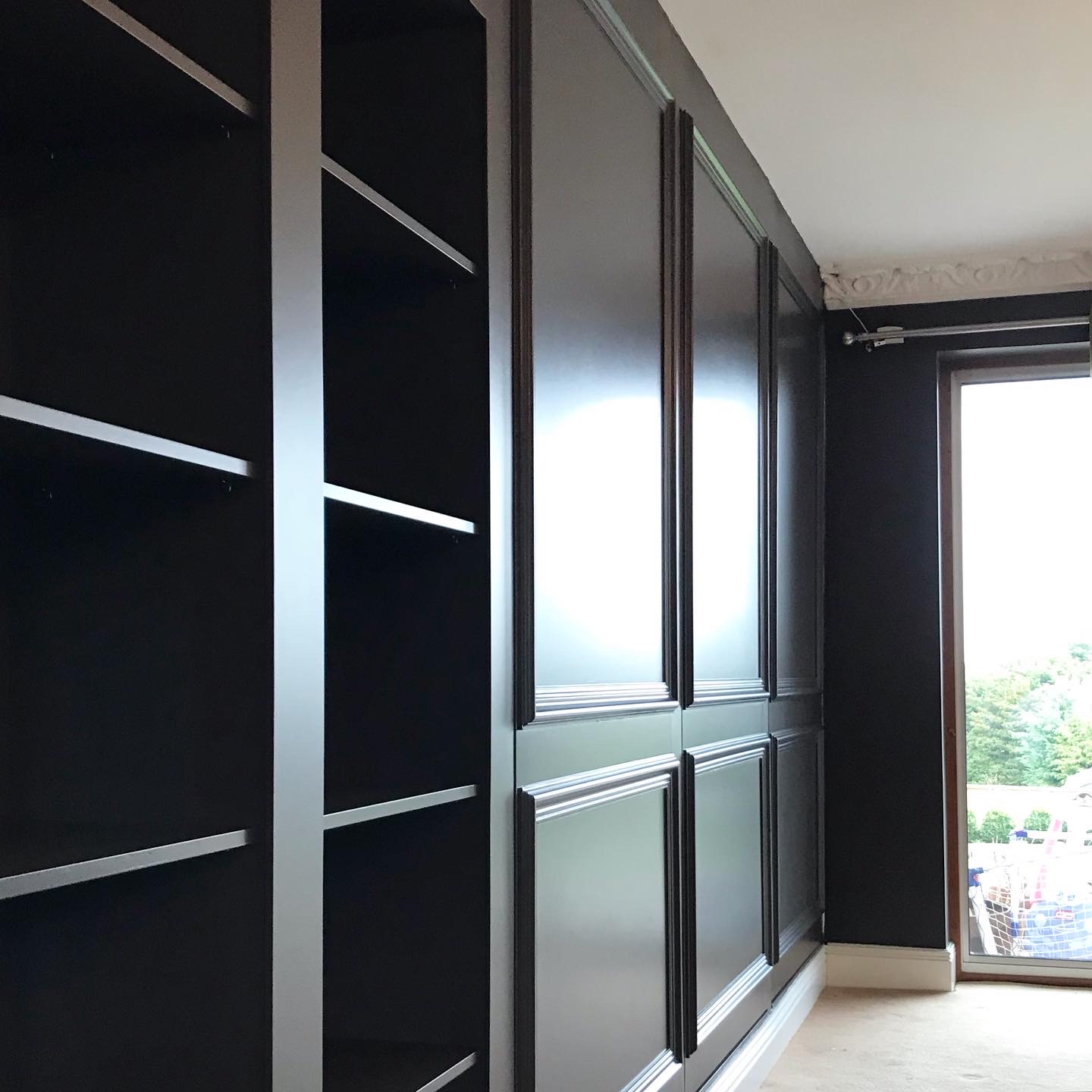 Floor to ceiling fitted storage units in dark blue